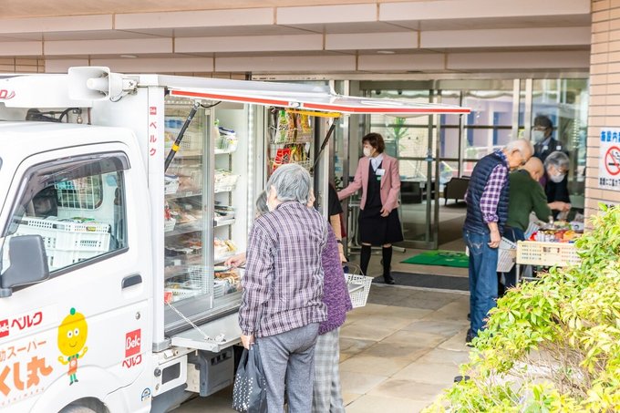 買い物する入居者と移動販売車