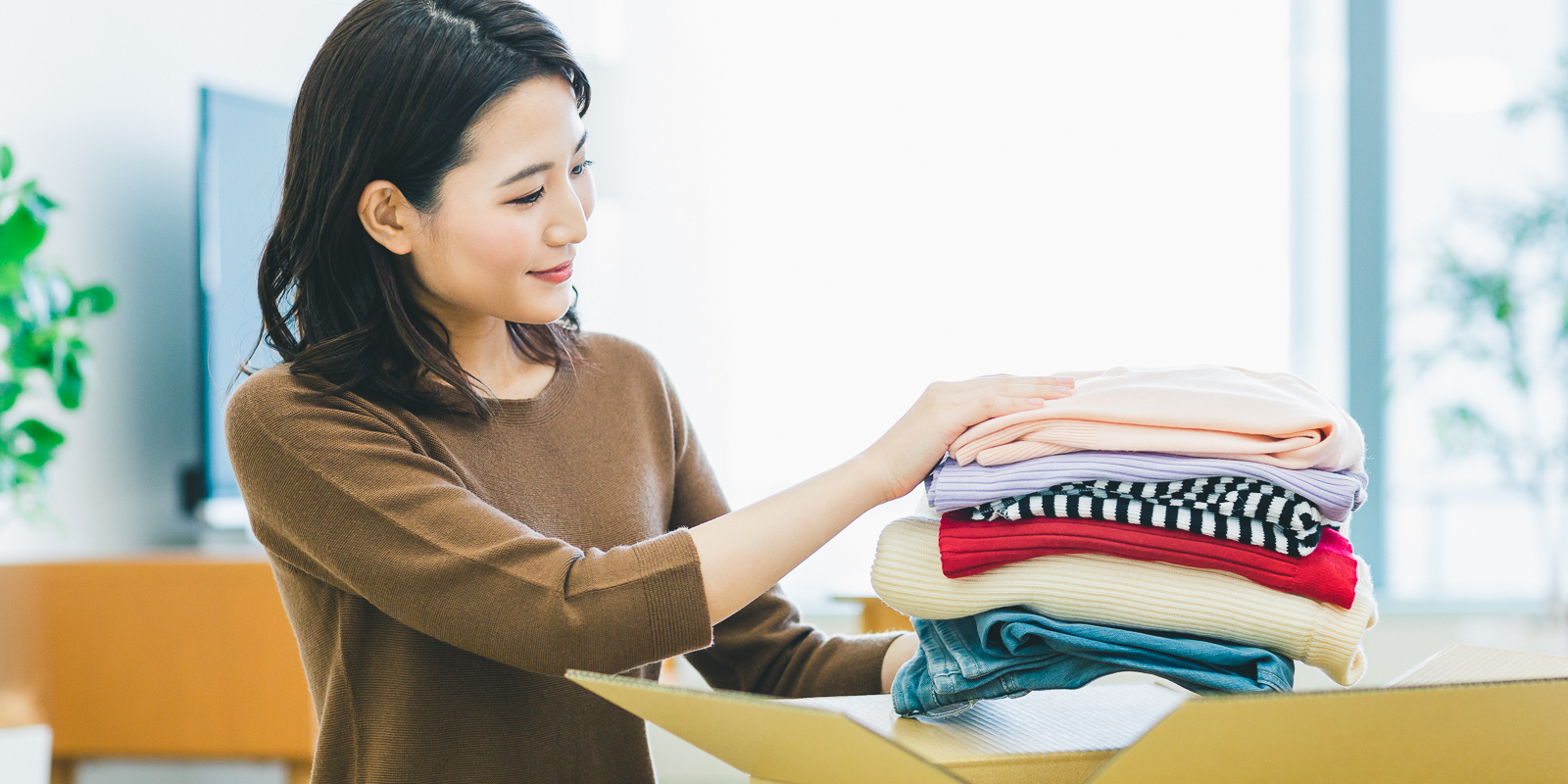 入居に必要な衣類を段ボールに入れる様子